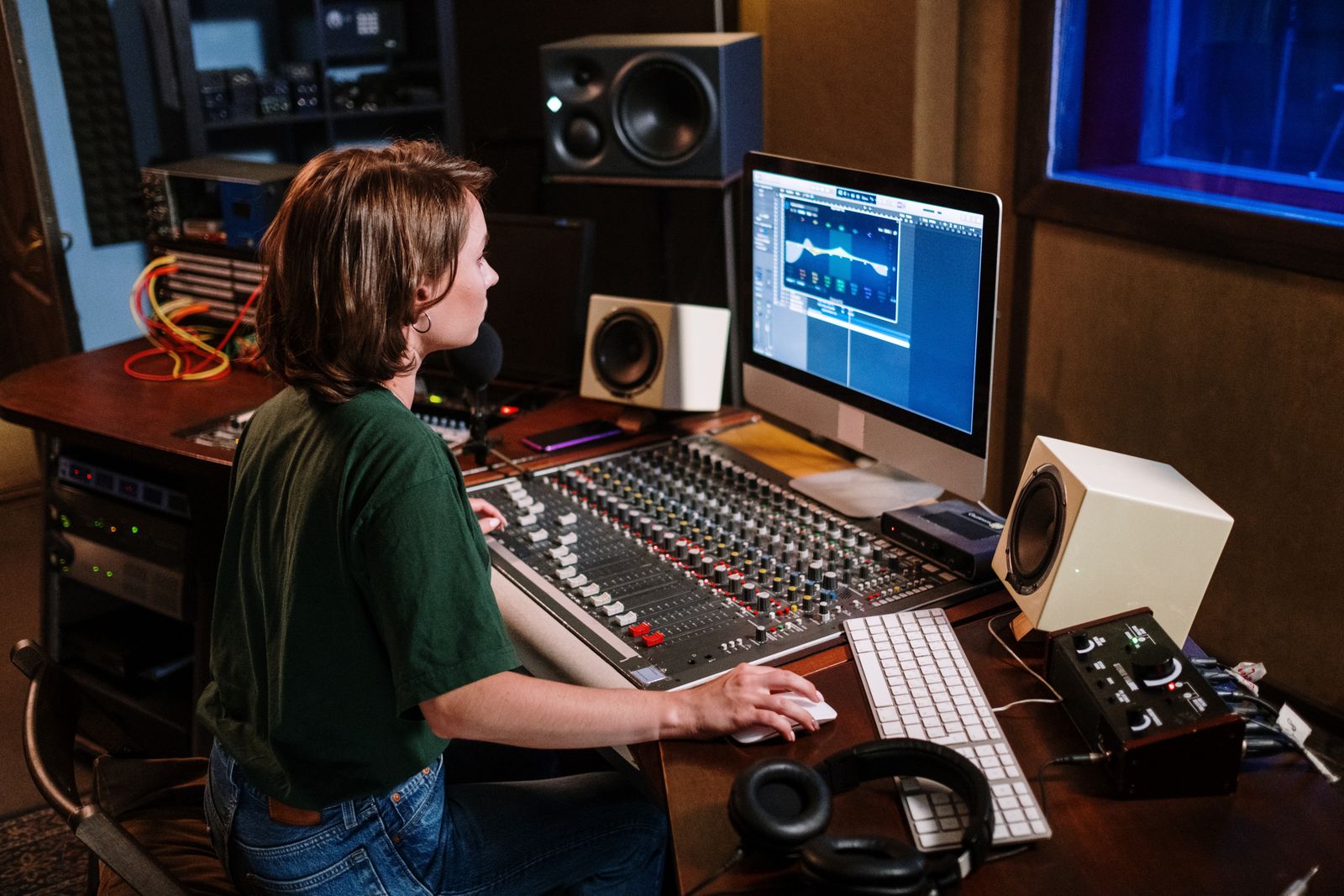 Stock photograph of audio work at a studio computer and mixing desk